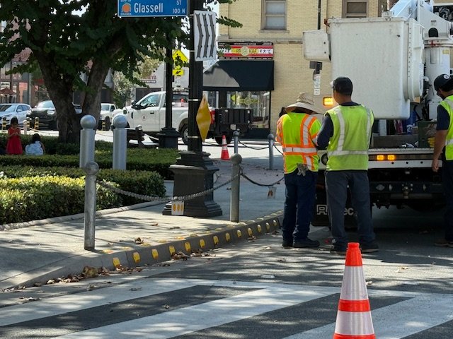 workers installing reflectors near orange circle