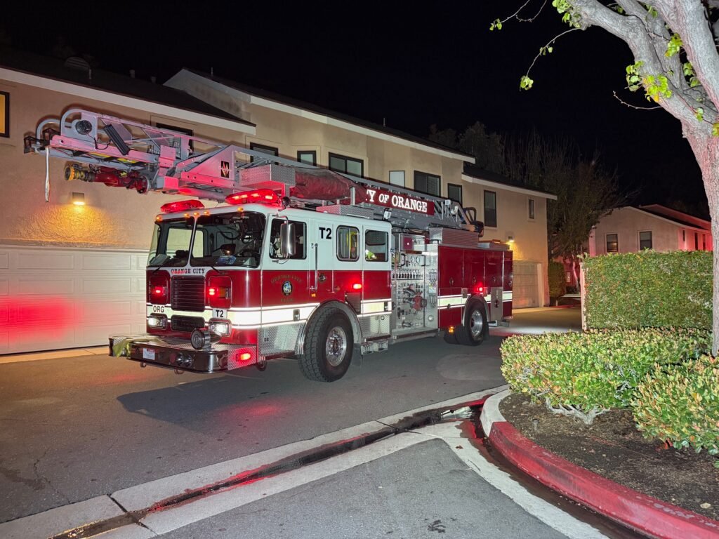 Orange City fire engine staged on residential street at the Villeurbanne condo complex during nighttime fire response.