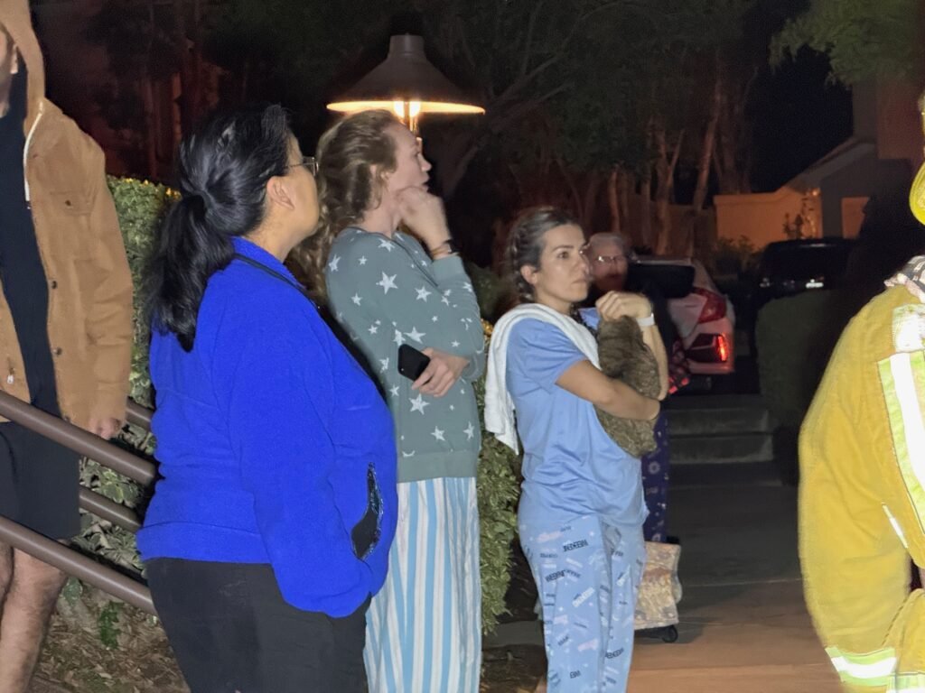 Residents watching firefighters operate at the scene of the condominium garage fire.