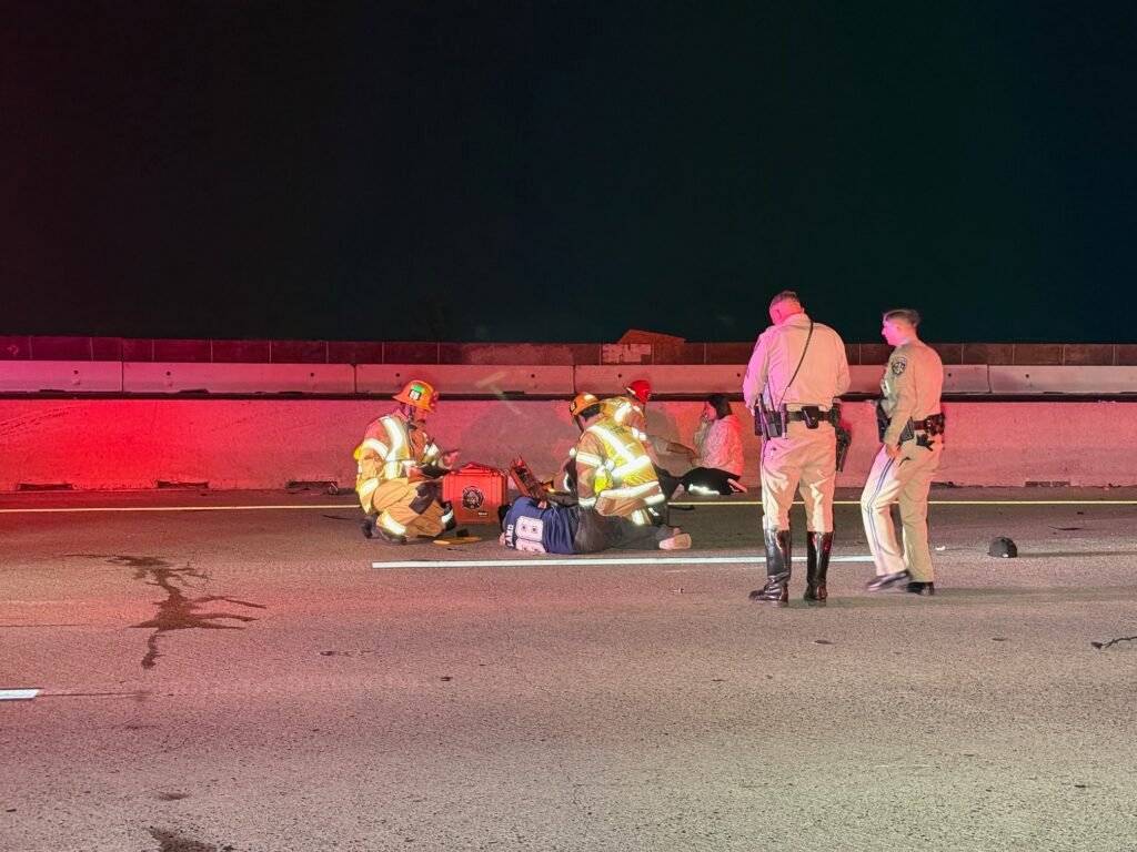 First responders assisting an injured person on freeway roadway