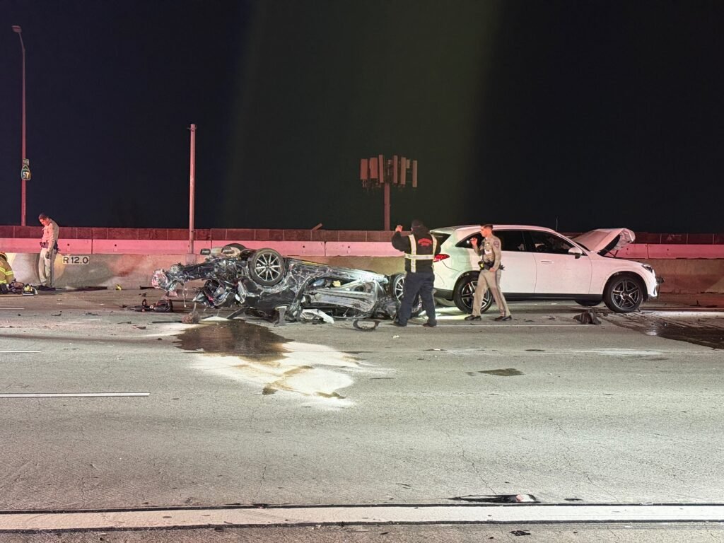 Accident scene with overturned car and responders assessing damage