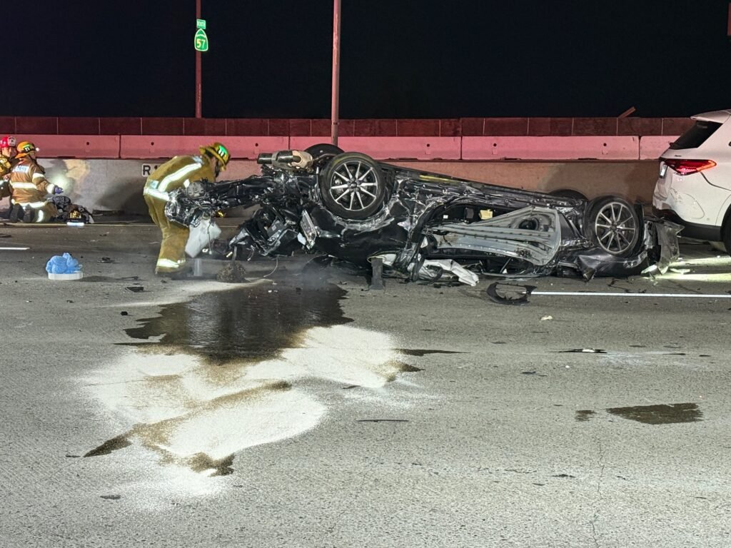 Accident scene with overturned car and responders assessing damage