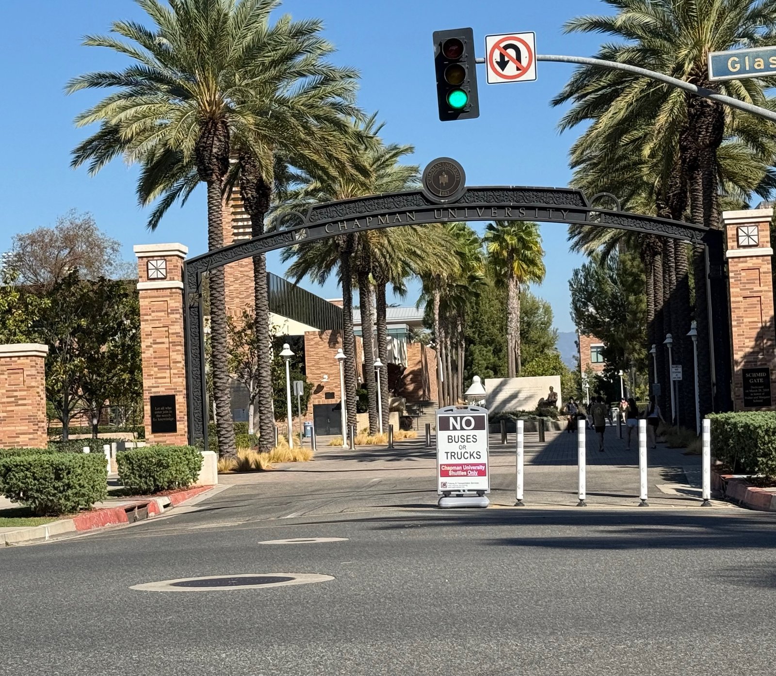Chapman University entrance arch over a palm-lined walkway.