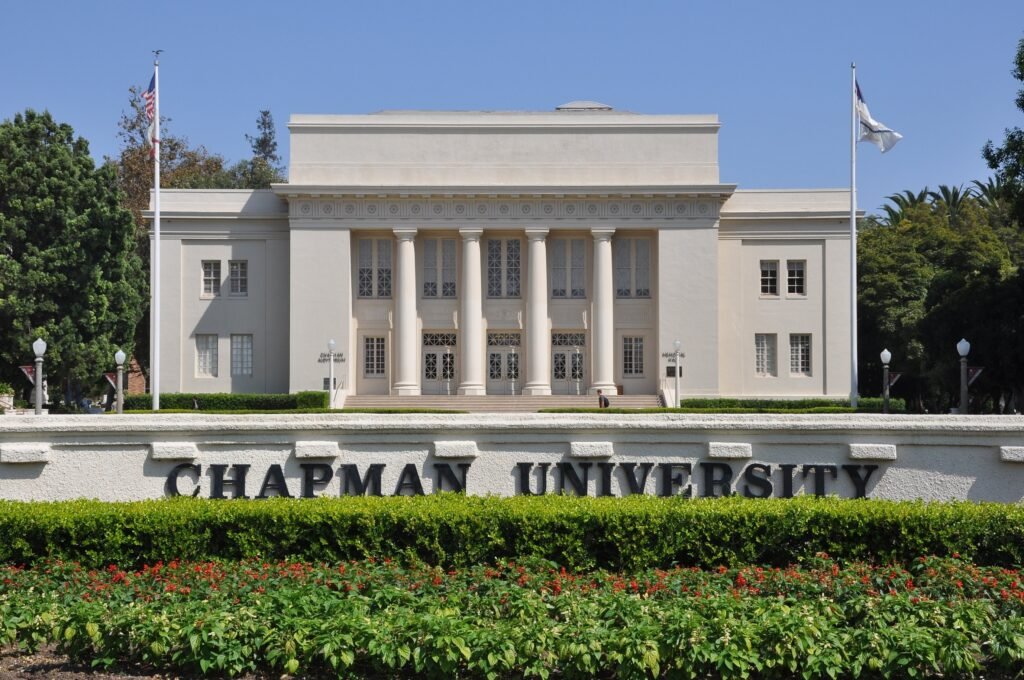 Columned building behind the Chapman University sign and gardens in Orange.