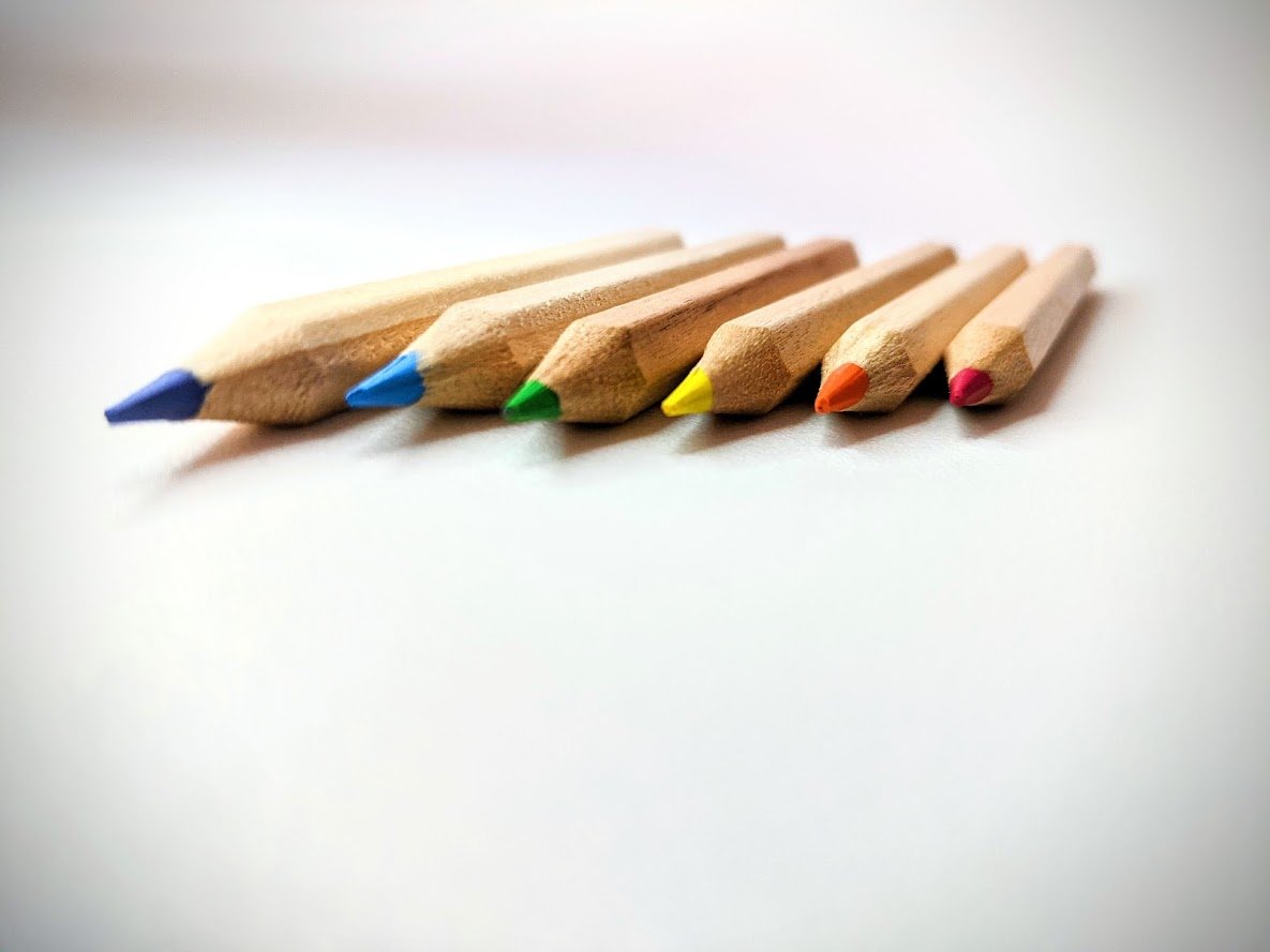 Six sharpened colored pencils arranged side by side.